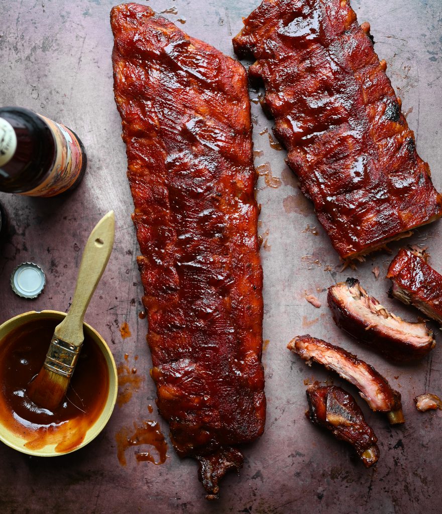 Overhead view of two racks of ribs with sauce